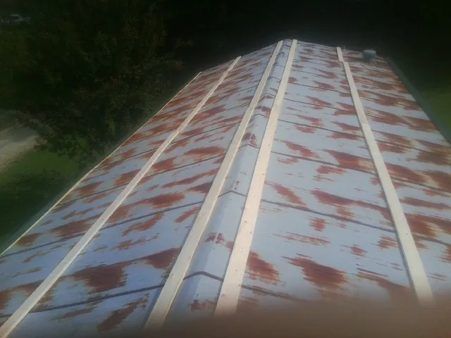 Rusted metal roof panels with new wood purlins before replacement — Storm Damage Roof Repair in Carolina by Roofing Brothers