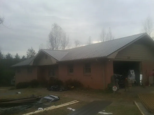 Gray metal roof on a stucco house with an attached garage in Carolina