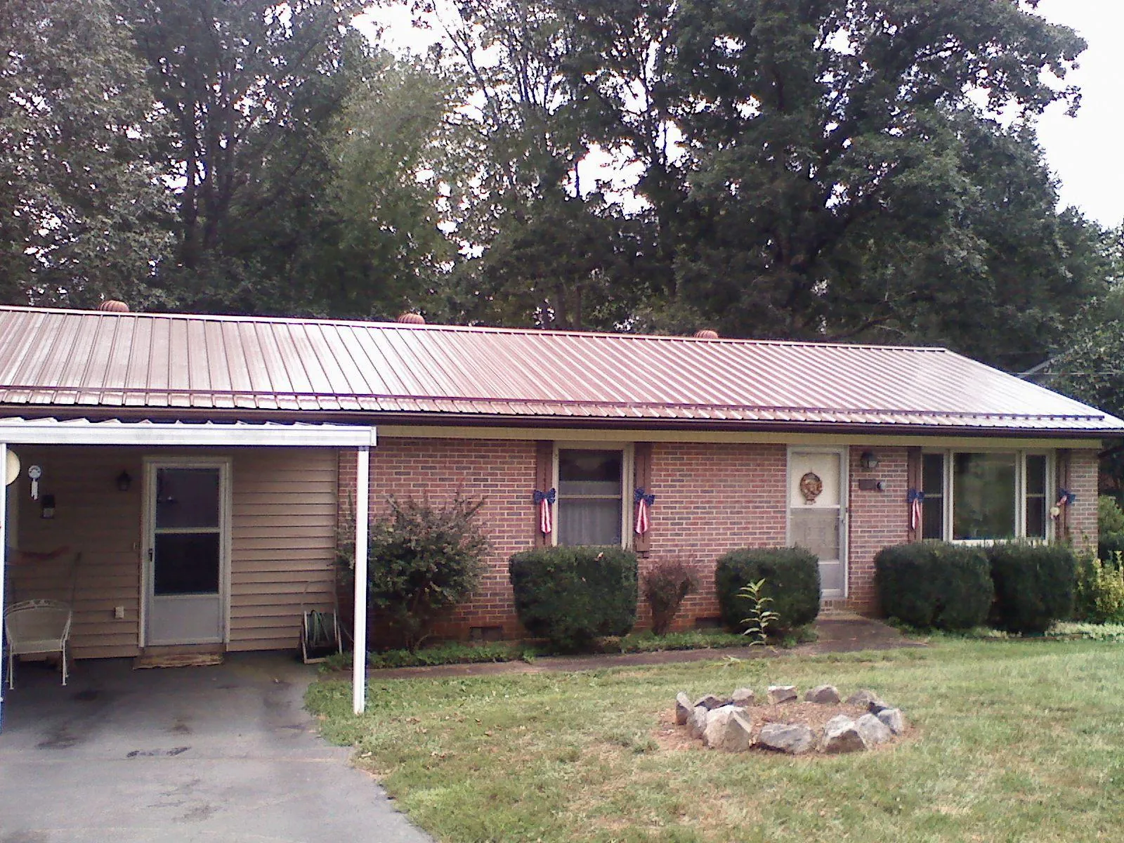 Bronze metal roof and carport on a brick ranch home — Roof Repair work by our crew in Carolina